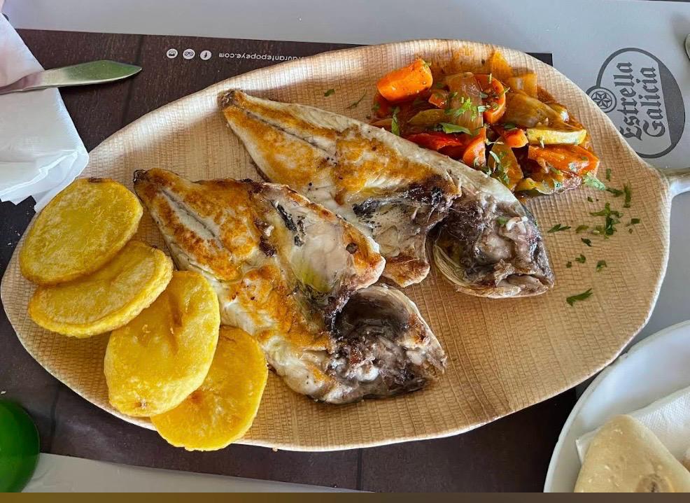Grilled lubina, split and served with fried potatoes