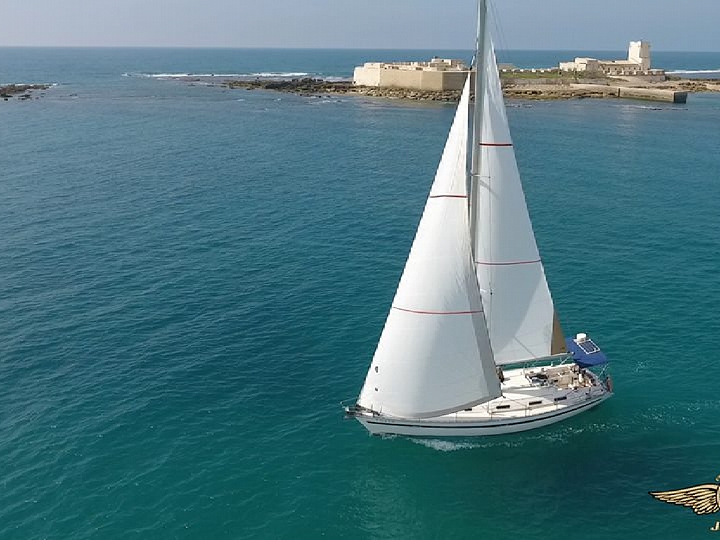 Sailing boat off the Sancti Petri coast with the castle behind